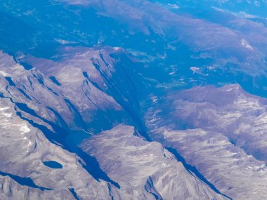 Alpler, uçağın penceresinden dağların manzarası. Toprak bükme ve doğa kavramı.