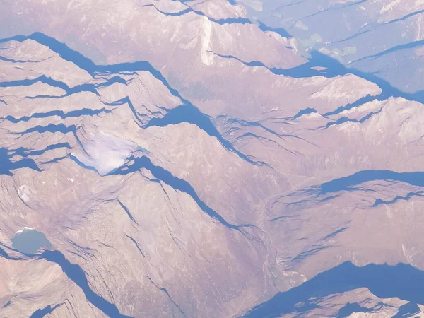 Alpler, uçağın penceresinden dağların manzarası. Toprak bükme ve doğa kavramı.