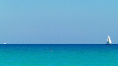 A boat in the turquoise waters of the Mediterranean Sea. Copy space on blue sky. Travel and leisure concept.