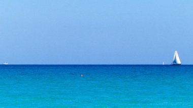 A boat in the turquoise waters of the Mediterranean Sea. Copy space on blue sky. Travel and leisure concept.
