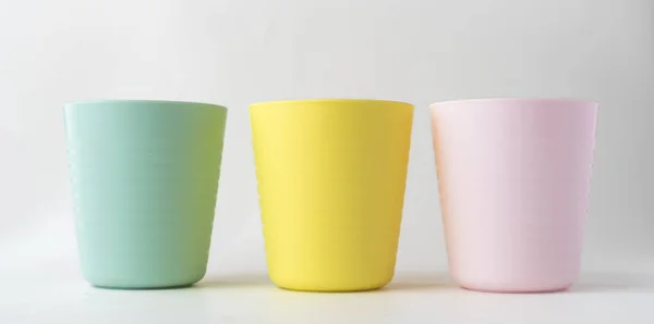 Beyaz arka planda izole edilmiş plastik bardaklar, renkli plastik bardaklar.