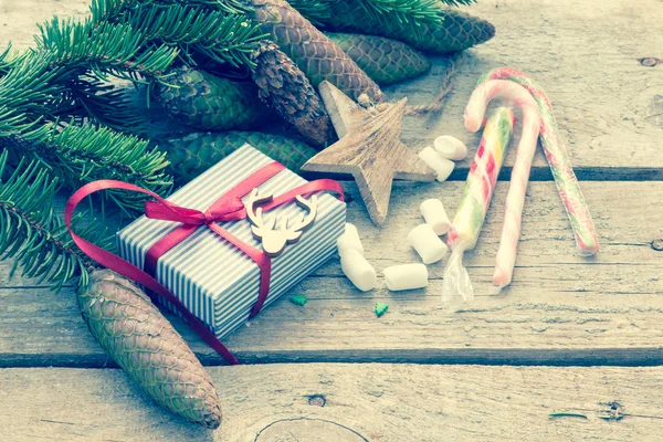 クリスマス プレゼント ボックス、木製の素朴なボード上のコーンとモミ枝との背景。クリスマス フレーム、コピーの領域での平面図。トーンの写真 — ストック写真