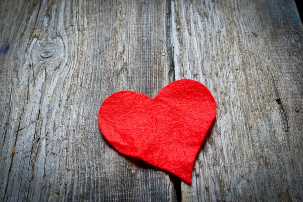 Corazón rojo sobre un fondo de madera — Foto de Stock