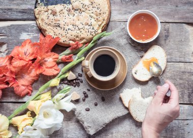 Bir masada fincan kahve ve çiçekler
