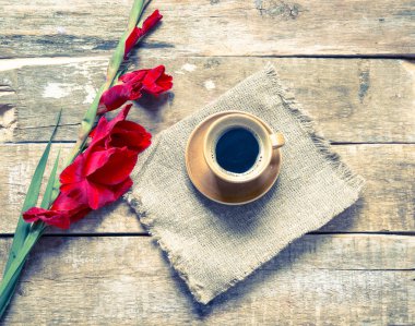 Bir masada fincan kahve ve çiçekler