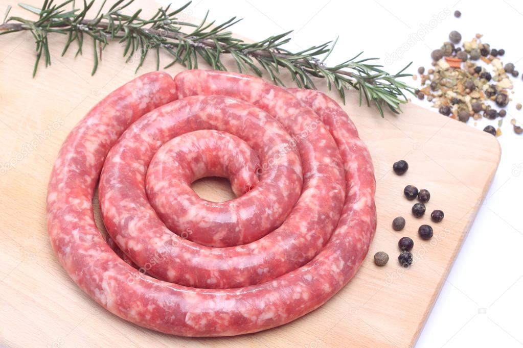 Raw sausage on wooden cutting board