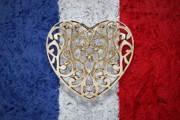 Coração de bronze na bandeira da França no fundo — Fotografia de Stock