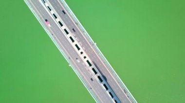 Yol yüzeyinin dikey hava görüntüsü ve nehir üzerindeki köprünün araçları.