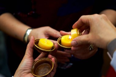 Kutsanmış küçük mum tutucuları olan insanlar.