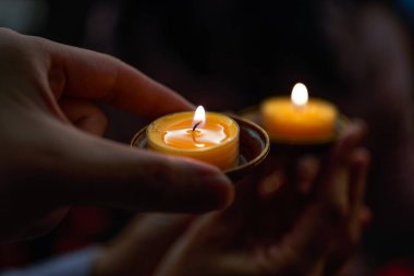 Kutsanmış küçük mum tutucuları olan insanlar.