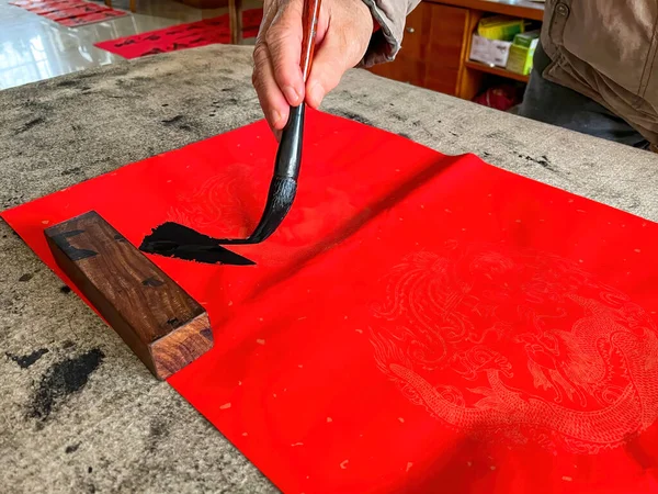 A calligrapher is creating and writing Spring Festival couplets, Chinese New Year Spring Festival. Translation: Spring is in many cities.