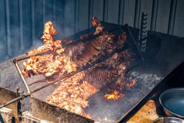 A whole crispy pork grilled on hot coals