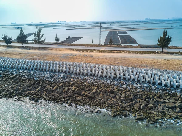 Cement block breakwater of coastal highway, aerial photography of highway seawall