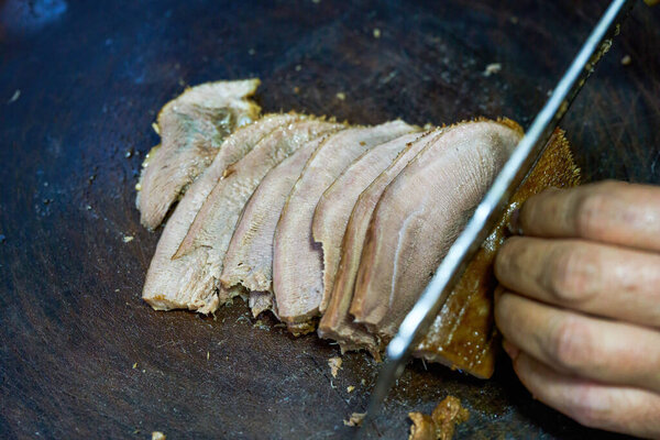 Шеф-повар режет тушёные блюда ломей, тушёные говяжьи языки