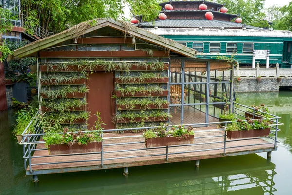 Artificial green wooden house on the lake
