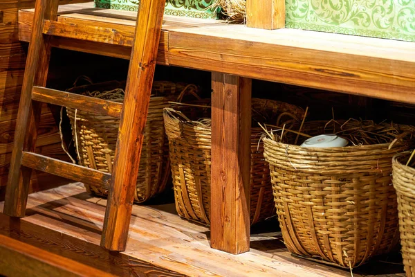 Closeup of woven rattan baskets and agricultural tools stored in the cellar