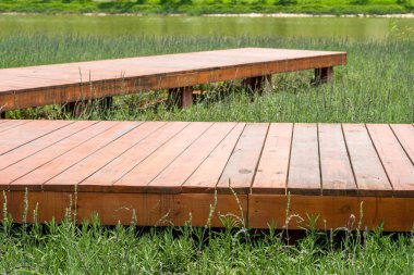 Walk along the water corridor by the lake in the park, and the footpath covered with water and grass