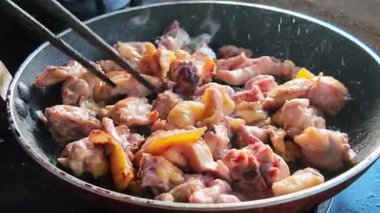 Bir şef tavada tavuk kızartıyor.