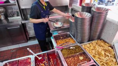 Bir şef Çin, Guangxi, Nanning 'de salyangoz erişte dükkanında erişte hazırlıyor.