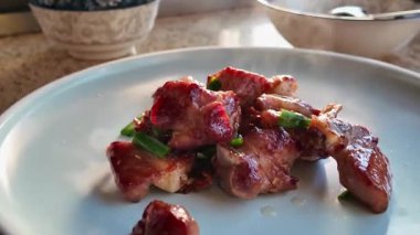 Bir şef kızartma tavasında domuz pirzolası pişiriyor.