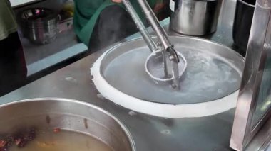 Nanning 'deki geleneksel bir yemek dükkanı çiğ pirinç eriştesi yapıyor.