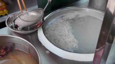 Nanning 'deki geleneksel bir yemek dükkanı çiğ pirinç eriştesi yapıyor.