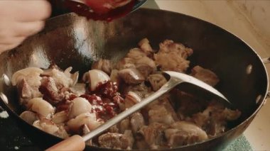 Bir şef tencerede kuzu pişiriyor.