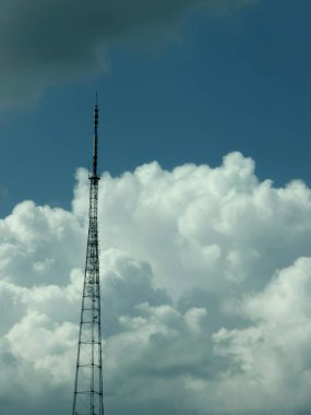 Mavi gökyüzü ve beyaz bulutların altında bir televizyon yayın kulesine yakın çekim
