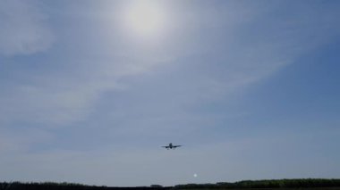 Bir ticari uçak yaklaşıyor ve havaalanı pistine iniyor..