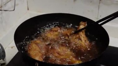 Bir şef yağda tavuk budu kızartıyor..