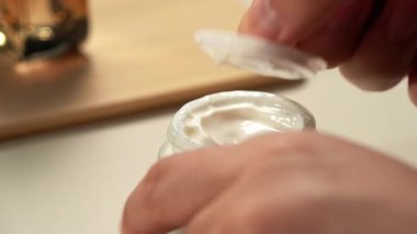 Çeşitli cilt bakım ürünleri, serumlar ve losyonlar kullanan bir kişi