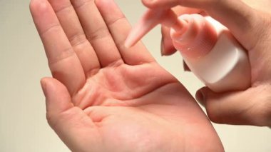 Çeşitli cilt bakım ürünleri, serumlar ve losyonlar kullanan bir kişi