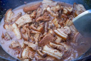 Bir. Çin usulü ağır ateşte pişirilmiş domuz eti ve bol soslu bir tencere..