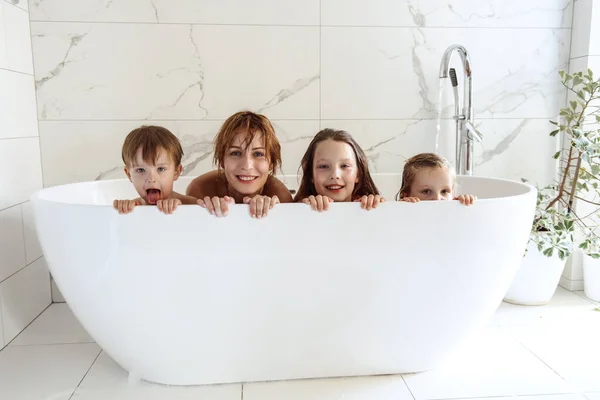 Anne, küçük kardeş eğleniyor ve banyo yapıyor.
