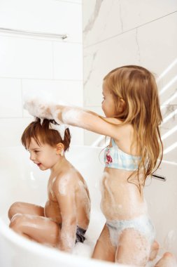 Küçük kardeşlerim eğleniyor ve köpük banyosu yapıyorlar.