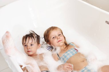 Küçük kardeşlerim eğleniyor ve köpük banyosu yapıyorlar.