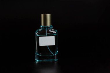 Siyah arka planda mavi parfüm şişesi