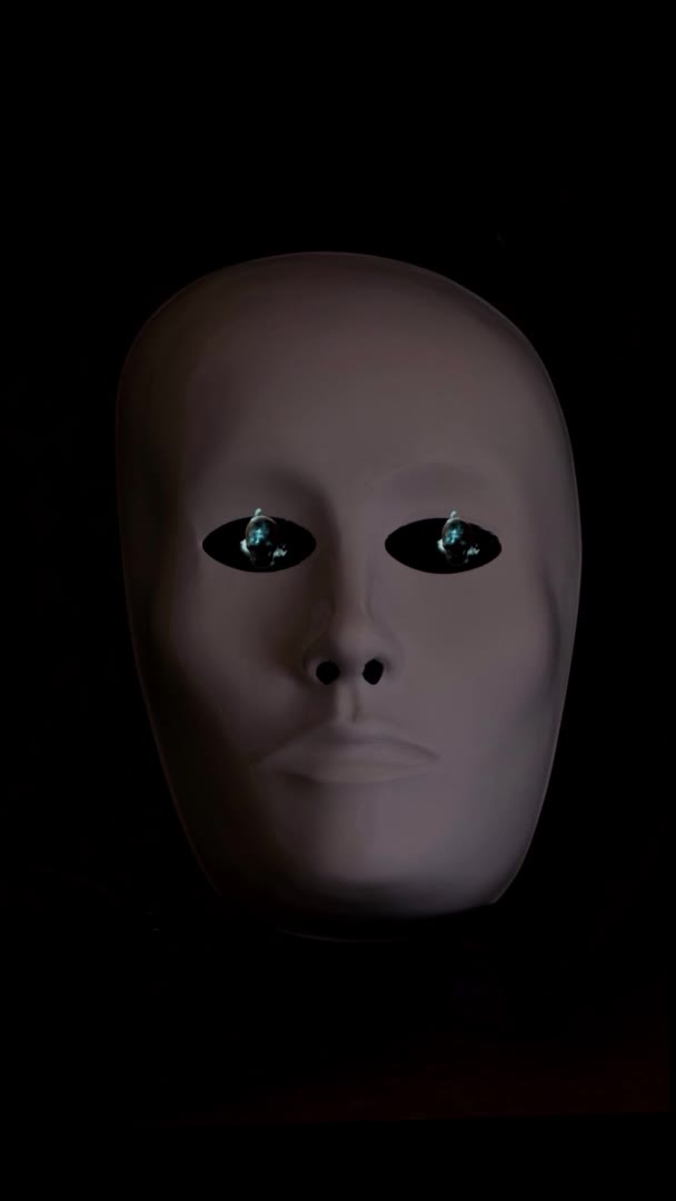 Ďábelská maska na černém pozadí, planoucí lebky vycházející z očí