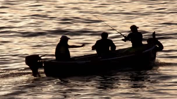 Трое рыбаков на моторной лодке на море утром — стоковое видео