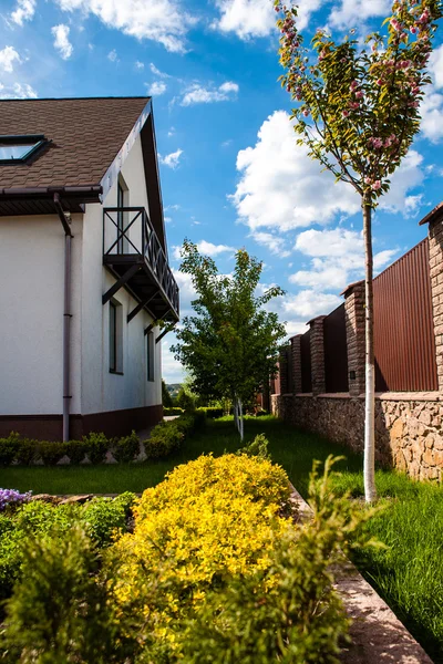 Casa para uma pequena família e um quintal ao lado dele em um fundo de céu azul — Fotografia de Stock