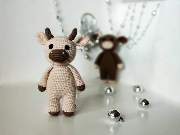 Pair of bulls on white background with Christmas decorations. Crocheted soft toys, handmade. 2021 — Stock Photo, Image