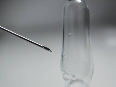 Işık arkaplan üzerinde şırınga ve ampul.