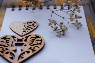  Sevgililer Günü arkaplanı ahşap kalp ve sarı arka planda beyaz çiçekler.