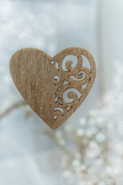 Sevgililer Günü arkaplanı ahşap güzel bir kalp ve açık arkaplanda beyaz çiçekler.