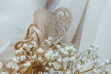 Sevgililer Günü arkaplanı ahşap güzel bir kalp ve açık arkaplanda beyaz çiçekler.