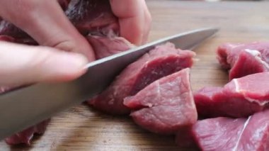 Tahtada bıçakla et kesen bir adam.