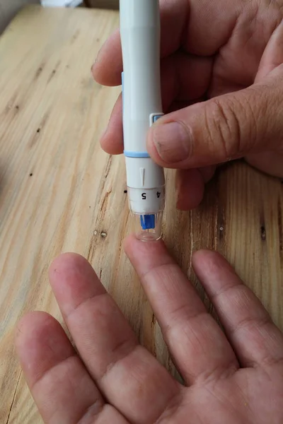 Beyaz arka planda kan şekeri monitörü kullanan diyabetik kadın.
