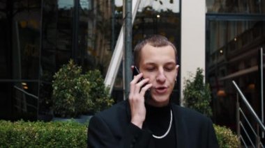 Dışarıda telefonla konuşan yakışıklı beyaz bir adam portresi. İş adamları sokakta akıllı telefondan konuşuyor. Mutlu adam dışarıdaki telefonu arıyor.
