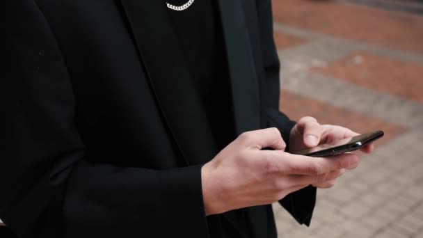 Close-up weergave van mannelijke handen typen op het telefoonscherm. Jongeman met behulp van zijn smartphone buiten. — Stockvideo