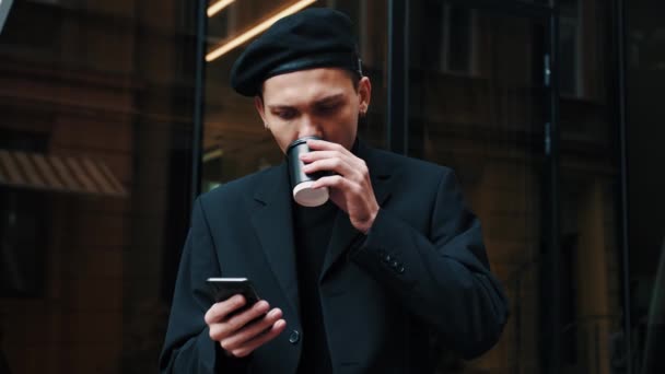 Smart casual klädd Office Worker dricker Coffe på Break. Attractive Man står nära moderna stora kontor och bläddrar i sin smartphone. Kontorsarbetare. Människor. Affärer. Telefoner. — Stockvideo